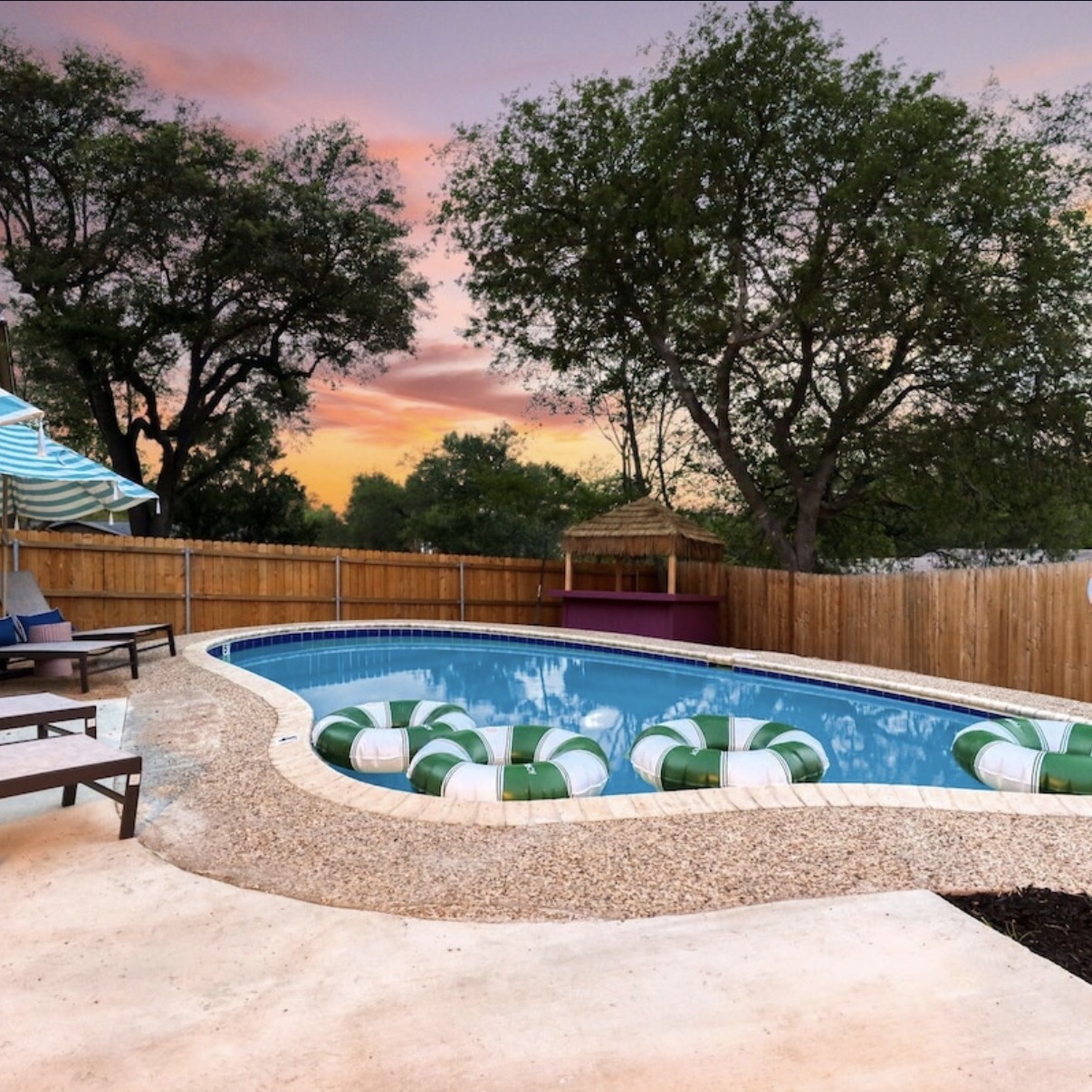 The heated pool at sunset, ringed with string lights